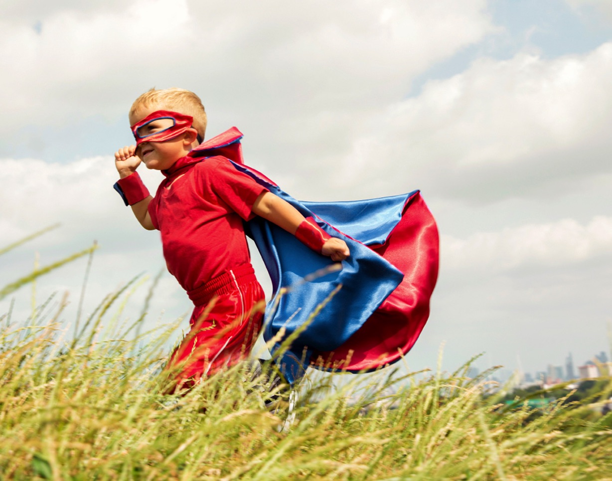 Little boy running in superhero costume